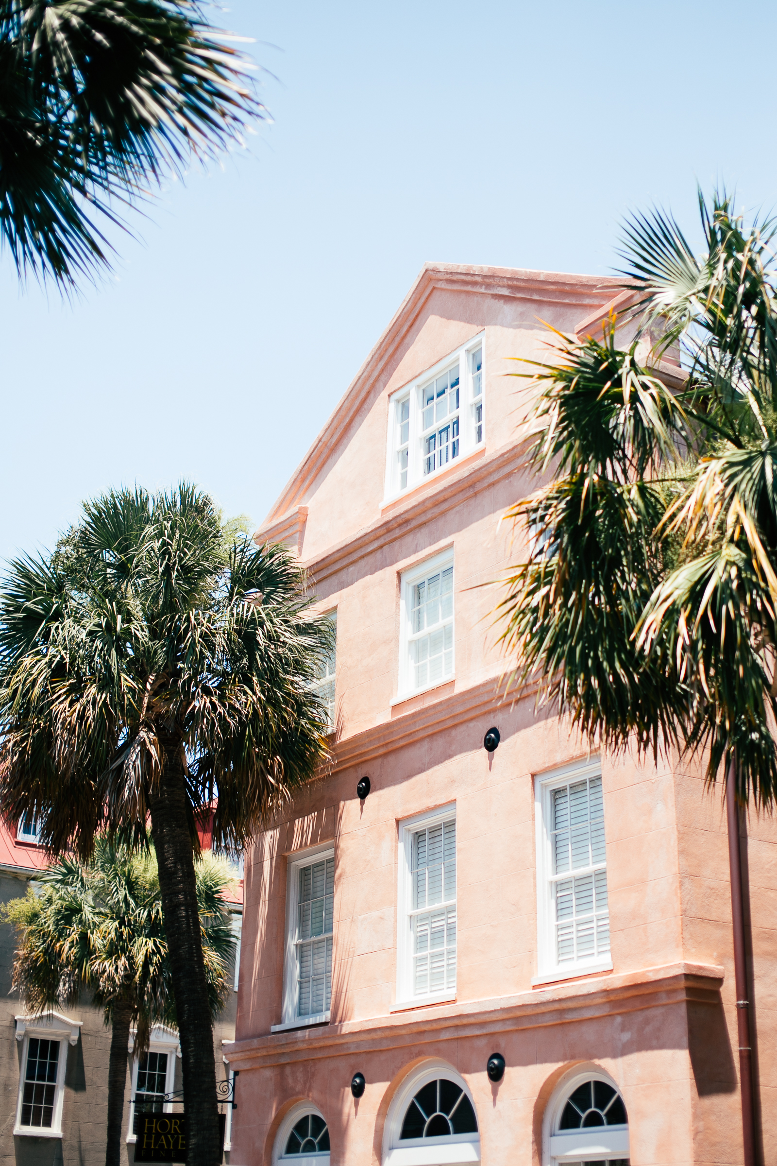 Pastel historic building with palm trees in Charleston SC