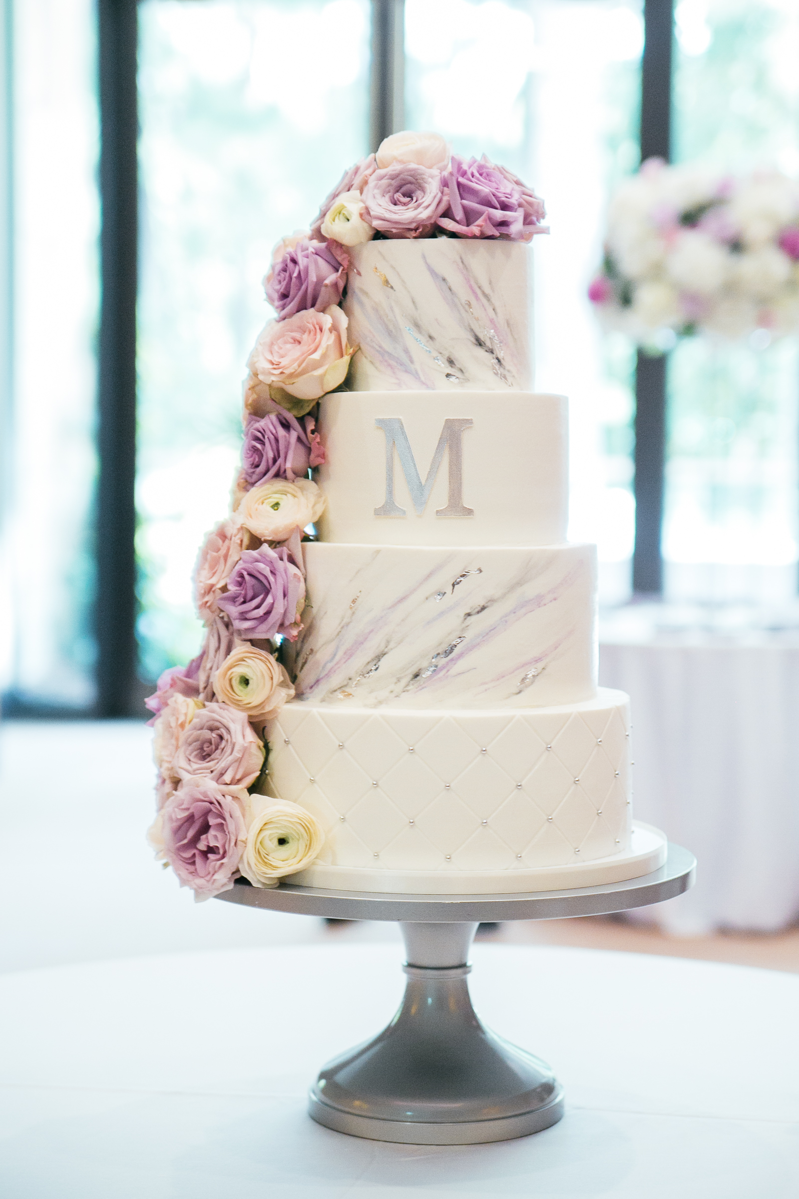 modern and stylish four tier wedding cake with marble design and flower cascade