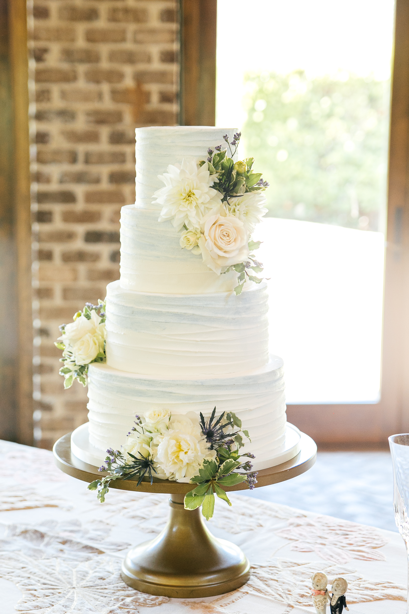 textured buttercream wedding cake with painted watercolor accents in dusty light blue with fresh flowers at the Sutherland